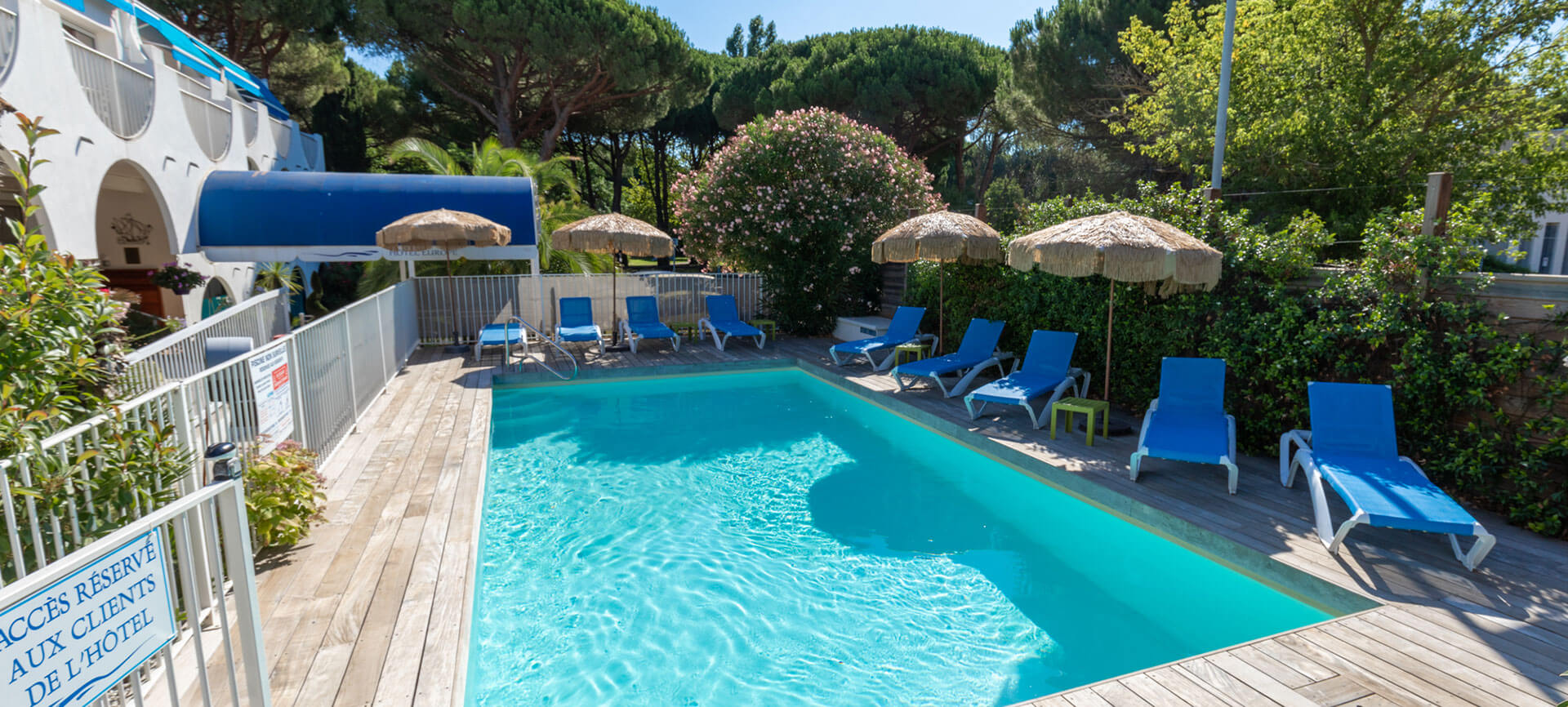 A large swimming pool with deckchairs for sunbathing at the Hotel Europe in the Hérault