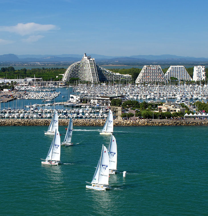 Segelboote auf dem Mittelmeer mit Blick auf die Gebäude und den Hafen von La Grande-Motte