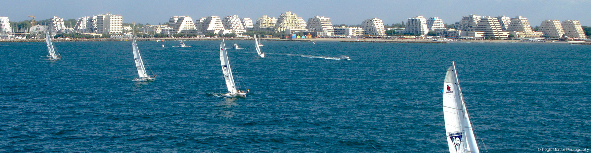 bateaux à voile sur la mer Méditerranée avec vue sur les immeubles de la Grande-Motte
